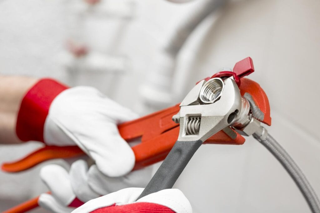 Plumber holding pipe wrenches for an emergency repair in Desert Hot Springs
