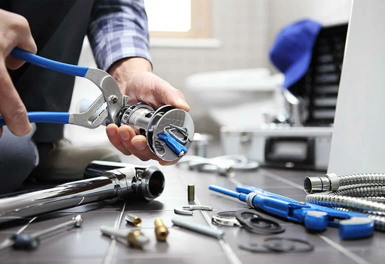 Technician repairing a plumbing fixture with professional tools in Desert Hot Springs
