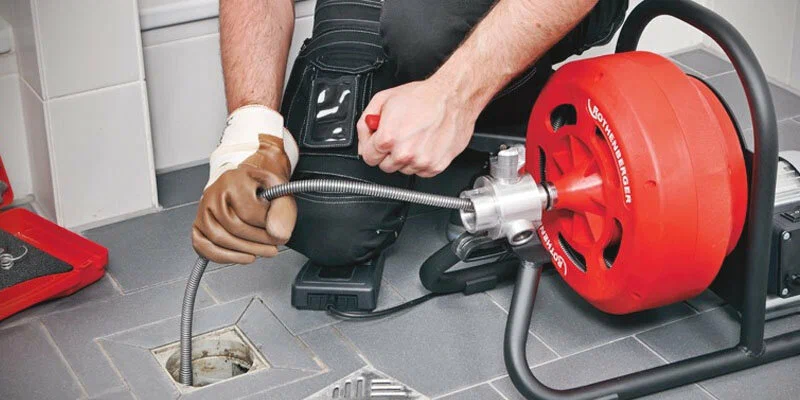 Plumber using a drain-cleaning machine in Desert Hot Springs