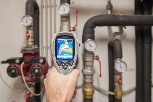 Plumber using a thermal imaging camera to inspect pipes in Desert Hot Springs
