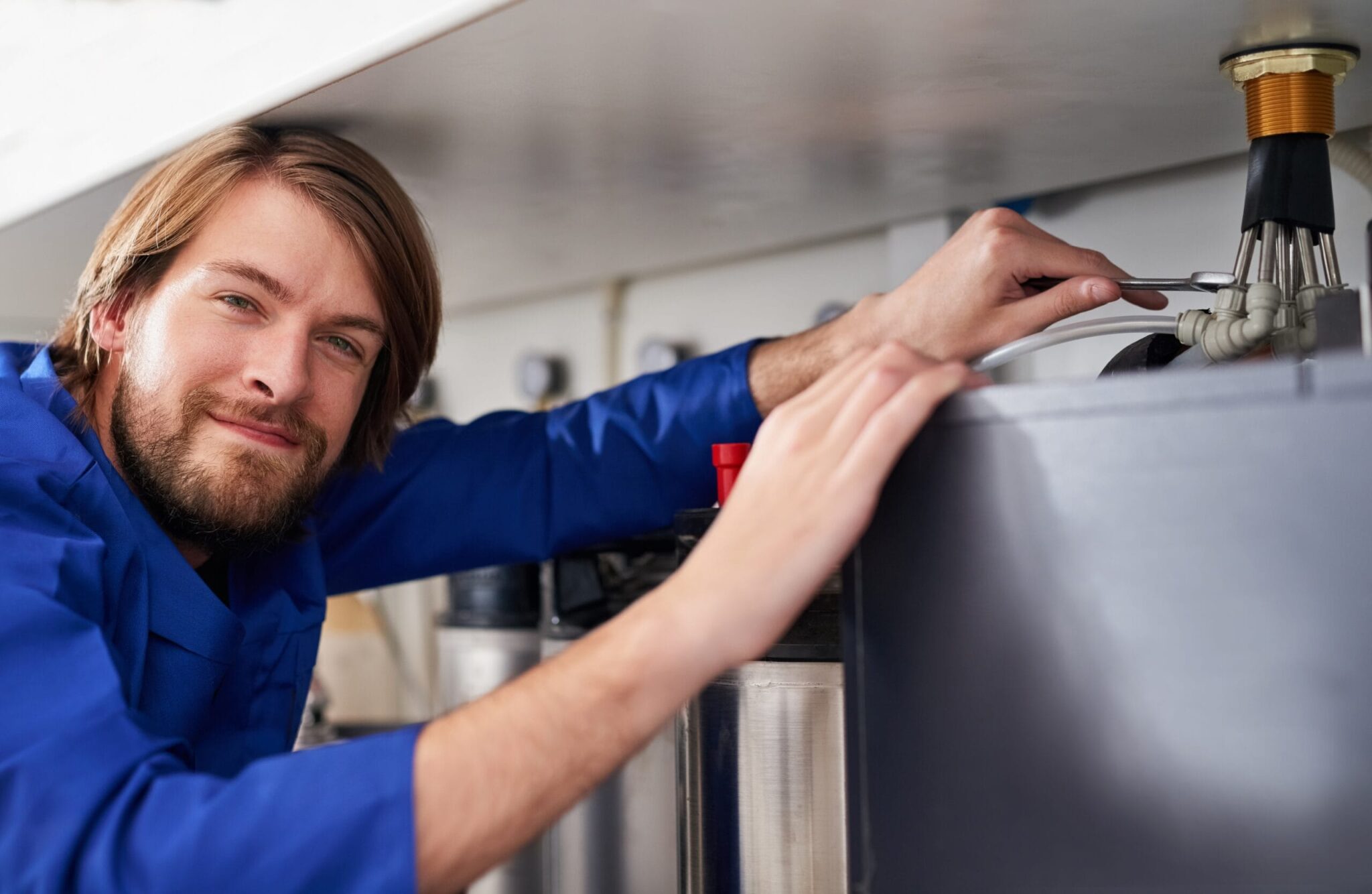 Technician servicing a residential water heater tank in Desert Hot Springs